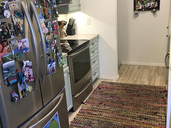 Stainless steel range with microwave, dishwasher and refrigerator included. Stairs to direct entry garage at the top left of the photo.