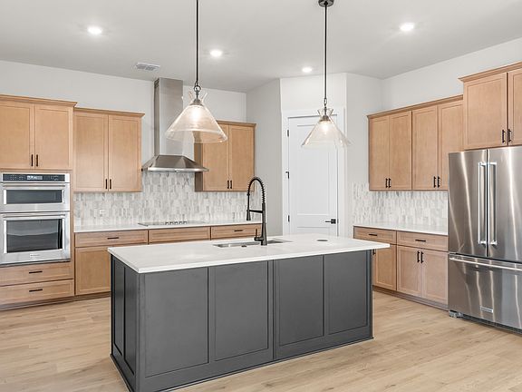 The kitchen has beautiful designer wood cabinetry.