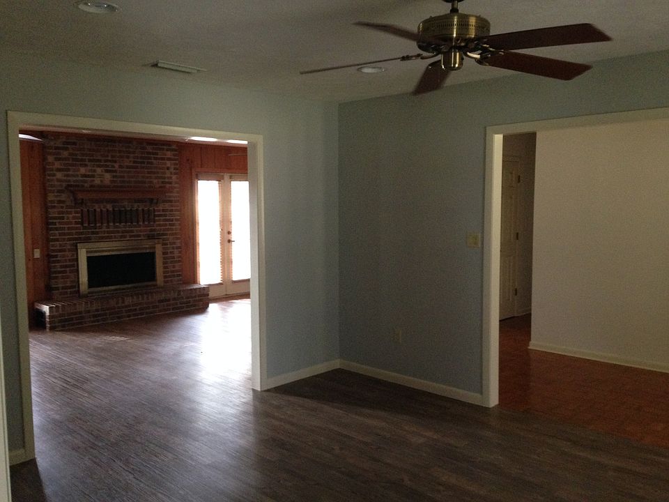 Living and dining rooms with fireplace overlooking back fiel