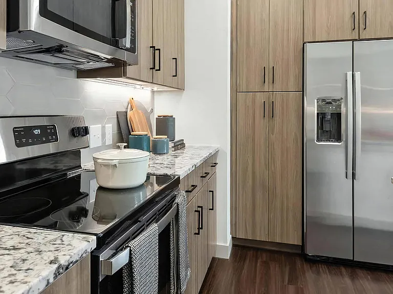 Kitchen Featuring Granite Countertops, Stainless Appliances, and Cabinets
