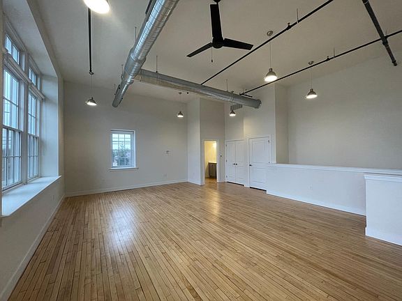 Open concept living and dining spaces with soaring ceiling height