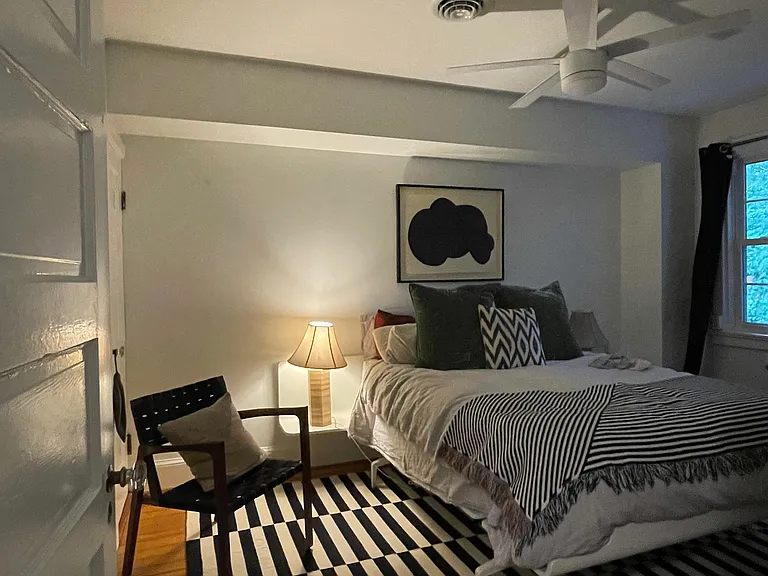 Bedroom 1 with original heart pine floors, modern ceiling fan and fresh paint.
