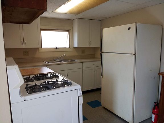Kitchen area with gas range and fridge.