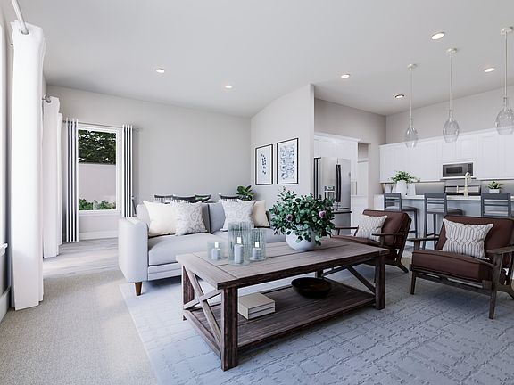 A modern and minimalist living room with a wooden coffee table, comfortable seating, and a kitchen v