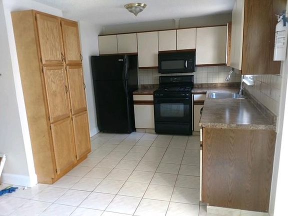 Kitchen with wall to wall storage. New counter tops, gas stove, dishwasher, built-in microwave, updated sink faucet.
