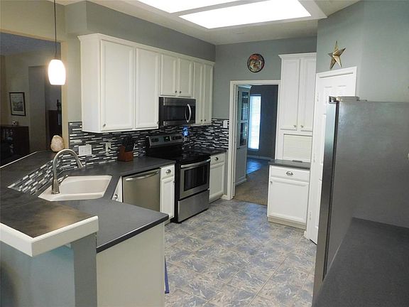 Large open kitchen with new stainless steel appliances and corian countertops.