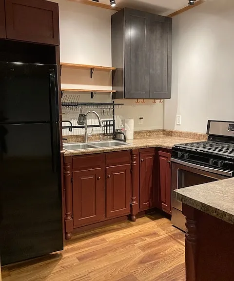 View of the kitchen with a new fridge and gas cooking stove