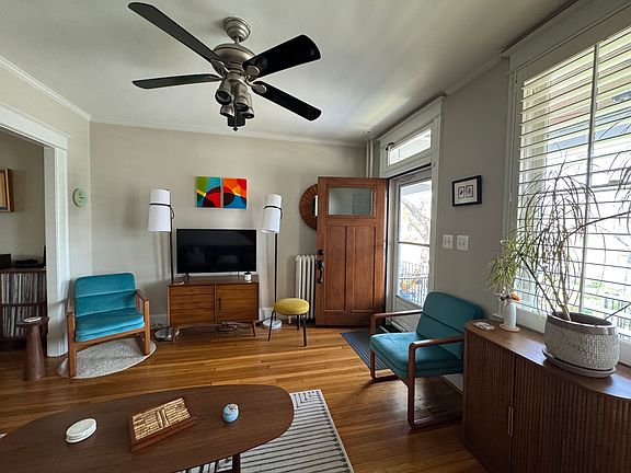 Living room with wooden shutters for easy opening/shutting and a new screen door that opens to let a cross breeze through _ perfect in spring and fall.