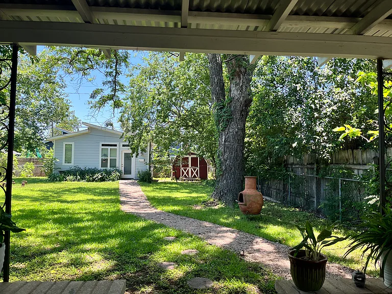 view of large fenced yard from back patio; back house has quiet renter; shed has space for both renters