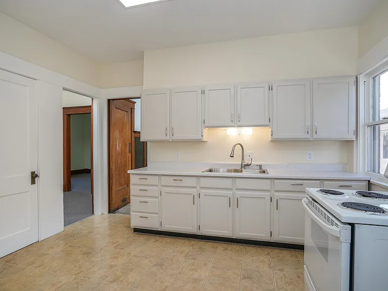 Cheerful Eat-In Kitchen with Ample Cabinet Space, Electric Stove and Pantry