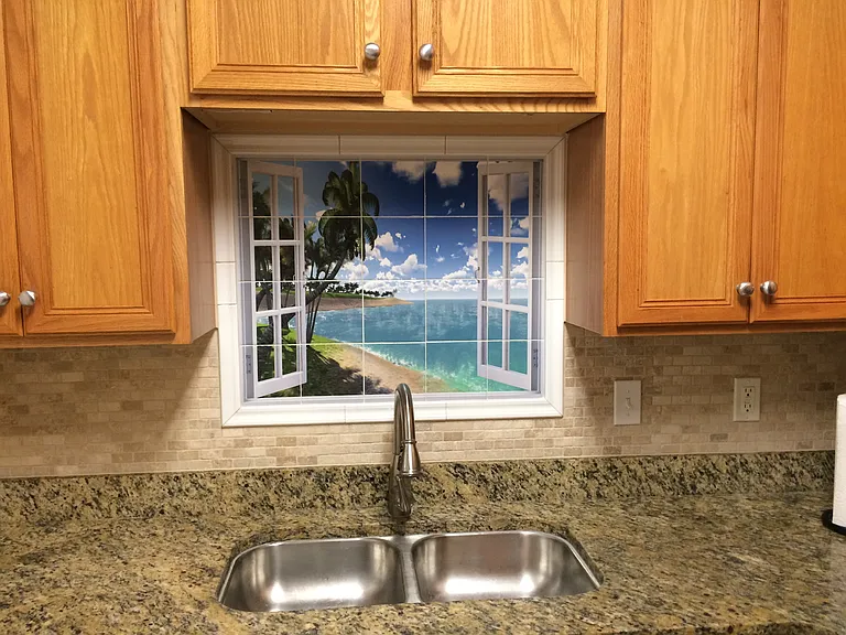 Granite countertop and tiled mural picture and tumbled marble backsplash in the kitchen.