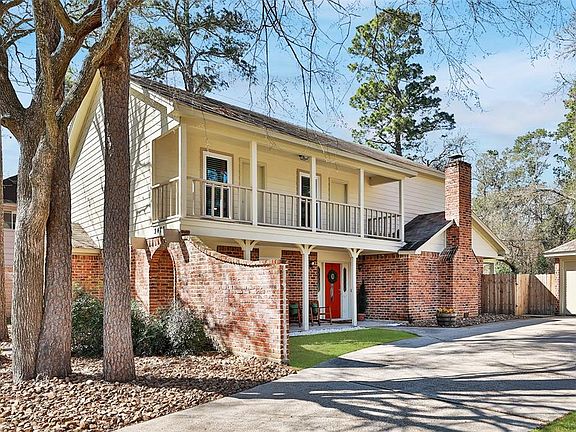Side view of the home shows the covered porch and covered balcony. They face the driveway.