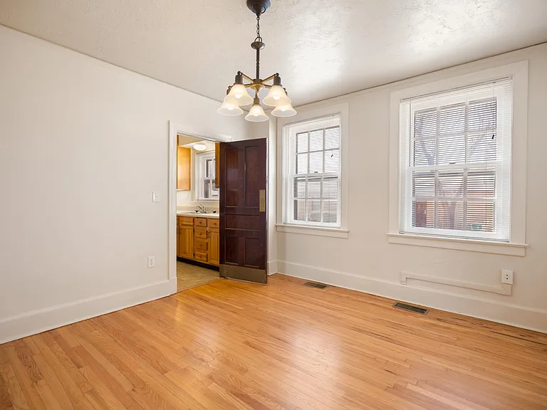 Well-lit formal dining room with wood floors.