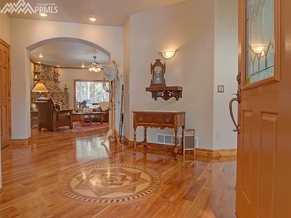 Main level boasts hardwood floors with custom hardwood mosaic inlay design in the entry