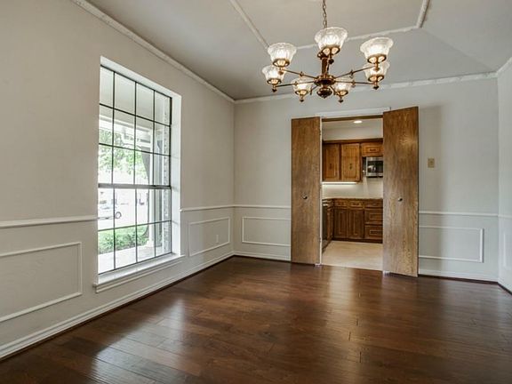 Spacious dining room has hardwood floors large windows for natural light and lovely chandelier. This