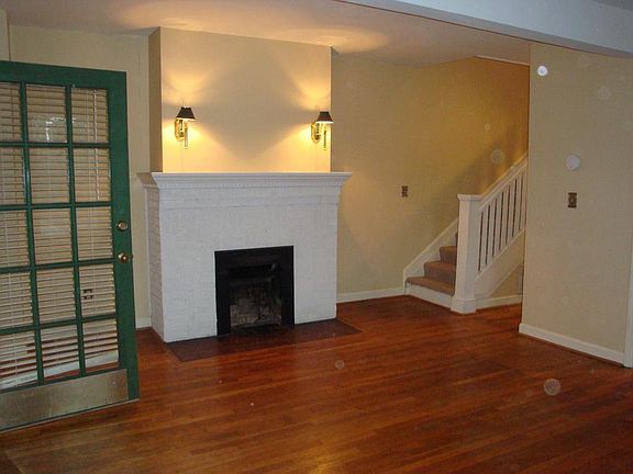 living room fireplace and stairs leading to full bath and 3 bedrooms