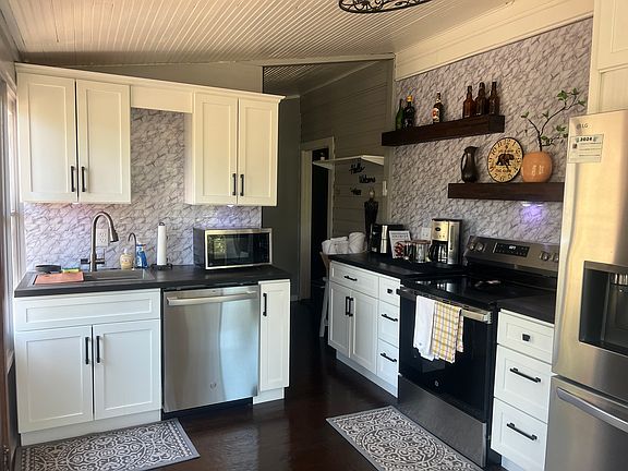 Kitchen has build-in ceiling fan with lights. Sink has cup washer