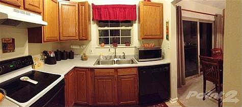Recently installed ceramic tile flooring enhances the beauty of the wood cabinetry.  Notice the full size pantry - not a common feature in a standard bi-level plan.