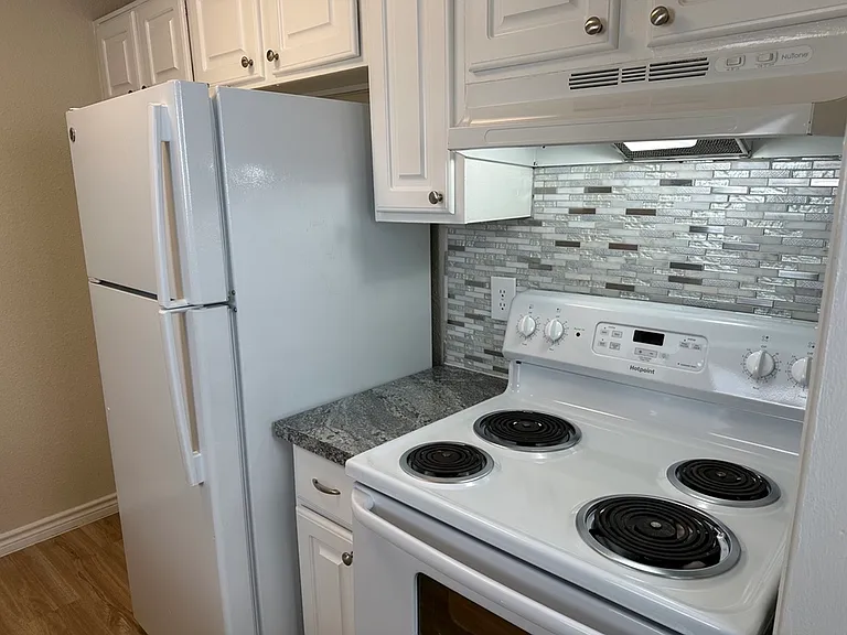 Modern kitchen featuring a sleek stovetop, elegant tile backsplash, and ample cabinet space. Modern kitchen featuring a sleek stovetop, elegant tile backsplash, and ample cabinet space.