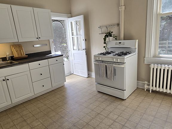 Large eat-in kitchen with a second entrance that leads to the private deck exclusively for Apartment #1.