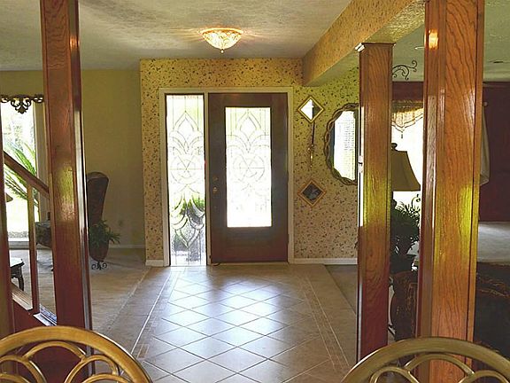 The leaded glass door opens to diagonally laid tile flooring and an open floorplan.