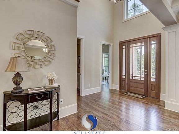 Beautiful solid wood door welcomes you into gleaming hardwood foyer filled with light.