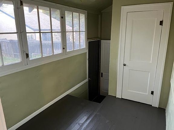 Back porch with stairs down to basement and outside doorway.