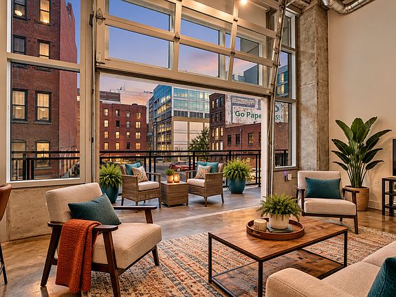 Living room with garage doors to large balcony. --Digitally Staged