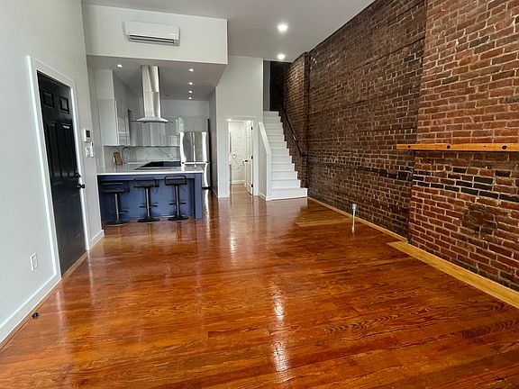 Living room with view of entryway and kitchen