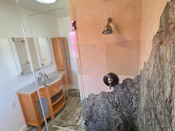 Bathroom with marble floor/shower; walk-in shower with built-in seat; window to side yard; skylights.