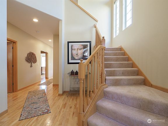 Dramatic entry flooded by natural light highlights stunning hardwood floors.>