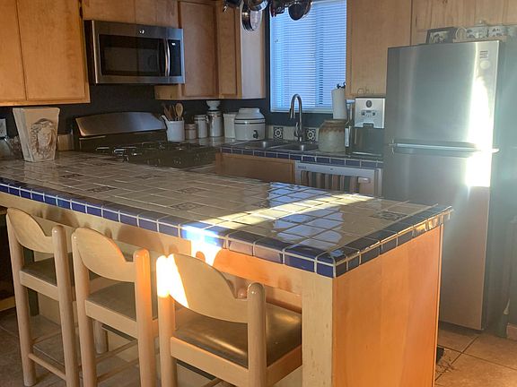 Kitchen with bar, gas stove, microwave, refrigerator and dishwasher.