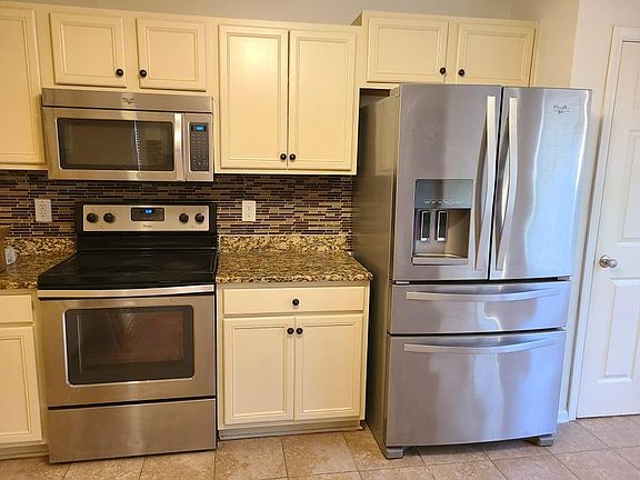 Stainless steel appliances with pantry door on the right