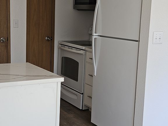 Another view of the kitchen. Slim door opens to the pantry. New microwave and cabinets.