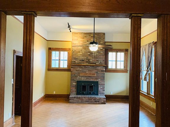 Picture was taken standing in the dining room looking towards the living room. The front door is located to the right. There is a bedroom located to the right. The other two bedrooms and two bathrooms are accessed through the door on the left side of the