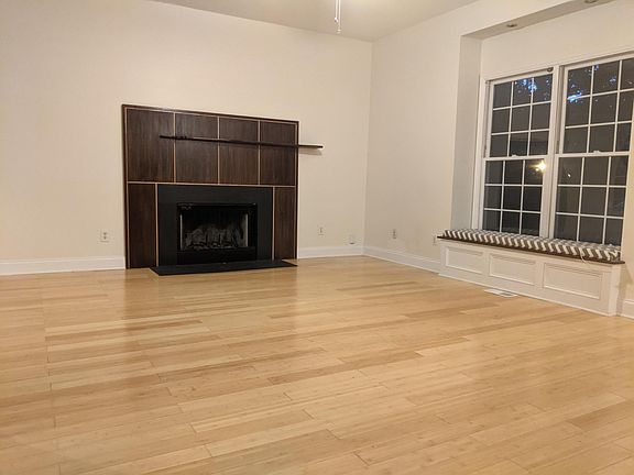 Living room with wood burning fireplace and window seat with cedar storage under the seat.
