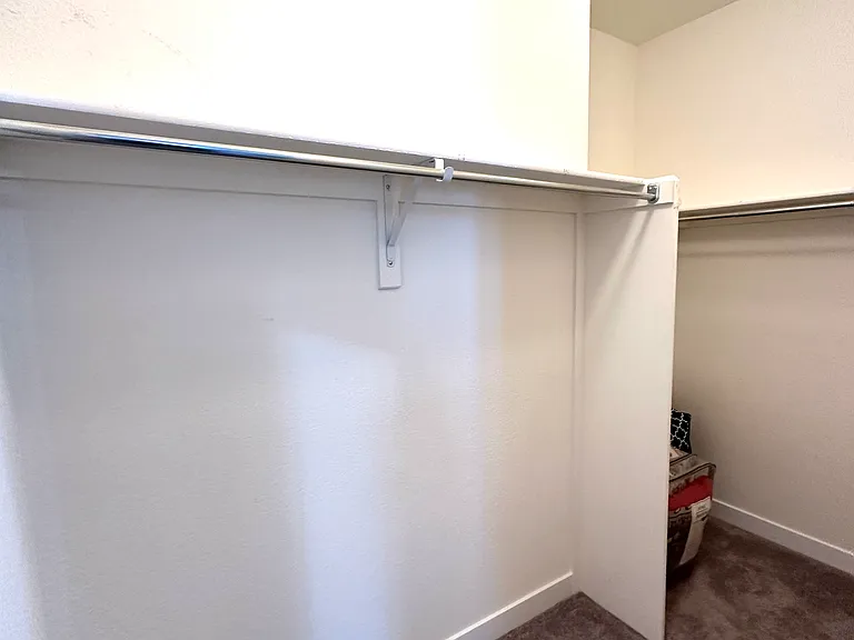The spacious walk-in closet offers ample room for clothing, shoes, and accessories, with plenty of additional space for storage and organization. Designed to accommodate a variety of needs, it provides a practical and convenient extension of the bedroom.