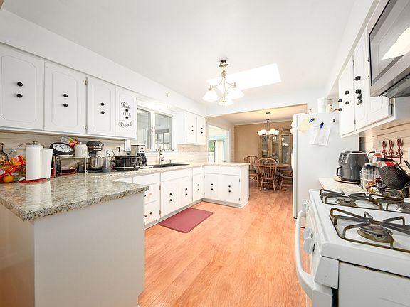 White cabinetry in kitchen with new countertops and sink/faucet