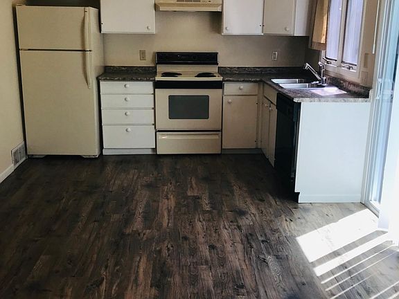 Kitchen food preparation area features refrigerator, electric range, hood, double sink, dishwasher and thermal curtains.