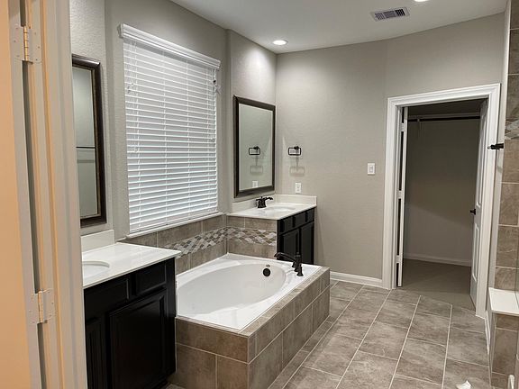 large tub in main bathroom area; large shower on opposite wall