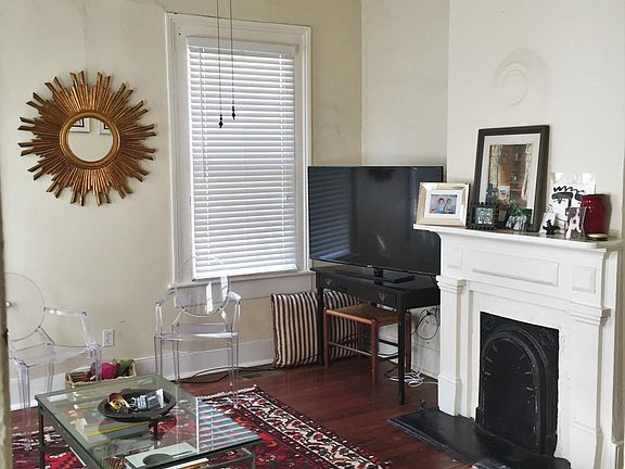 Living room has 4 large windows and a decorative fireplace (non-working) - unit does not come furnished