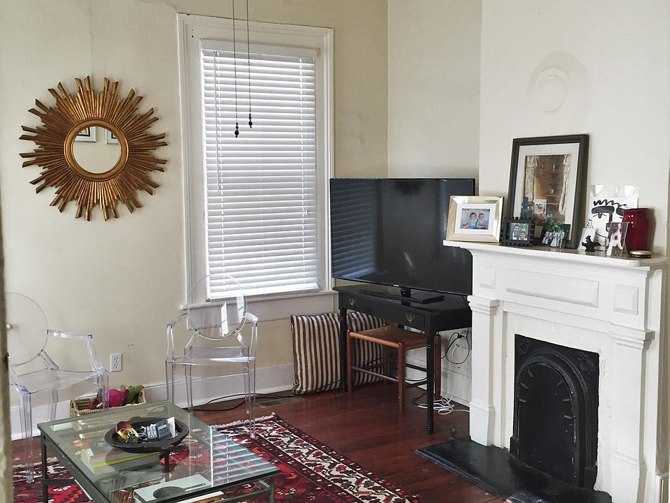 Living room has 4 large windows and a decorative fireplace (non-working) - unit does not come furnished