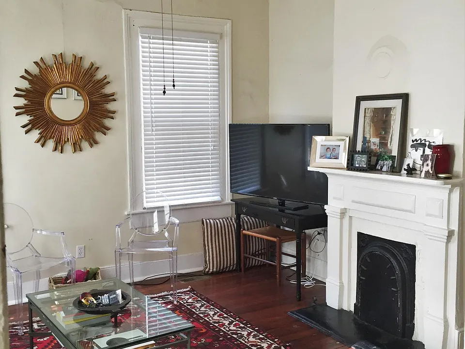 Living room has 4 large windows and a decorative fireplace (non-working) - unit does not come furnished
