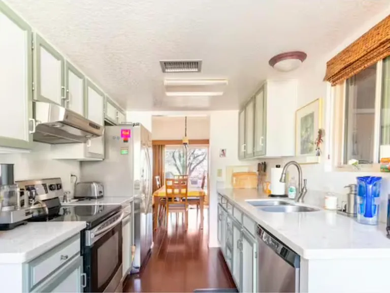 Small but perfectly formed kitchen opens out to the dining room, with beautiful wooden table.
