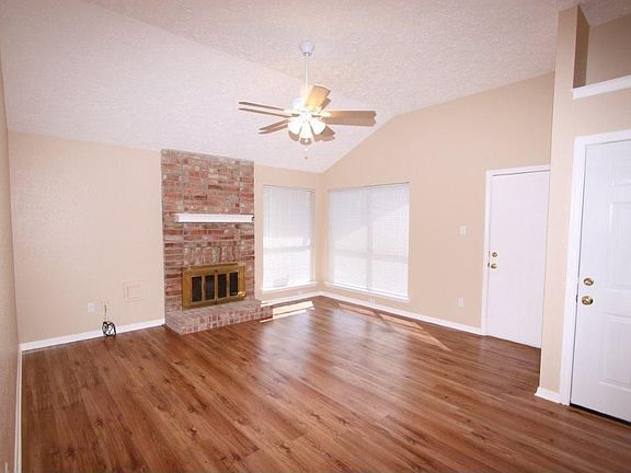 LIVING AREA WITH WOOD BURNING FIREPLACE AND WOOD LAMINATE FLOORS