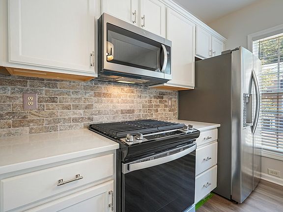 Kitchen Tumbled Travertine Backsplash with Appliance and Quartz Countertops
