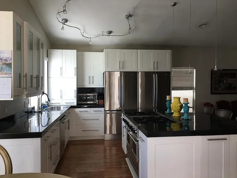 Kitchen with double stainless refrigerators and 48" Viking gas stove.