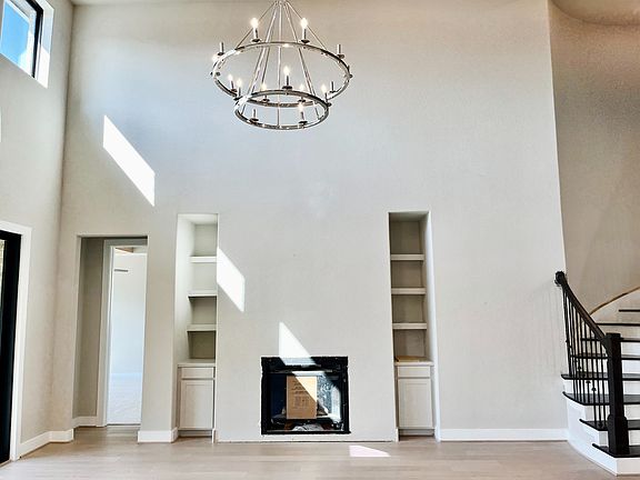Two story family room with fireplace and modern chandelier