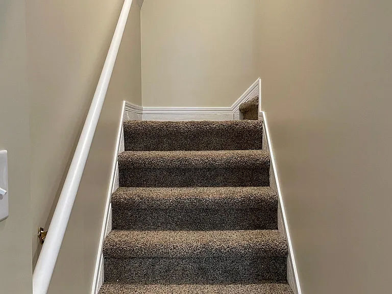 Carpeted stairway to the upstairs bedrooms and full bath.