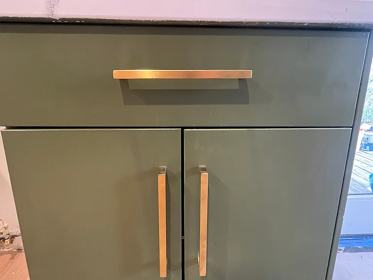 Green base cabinets with gold finshes